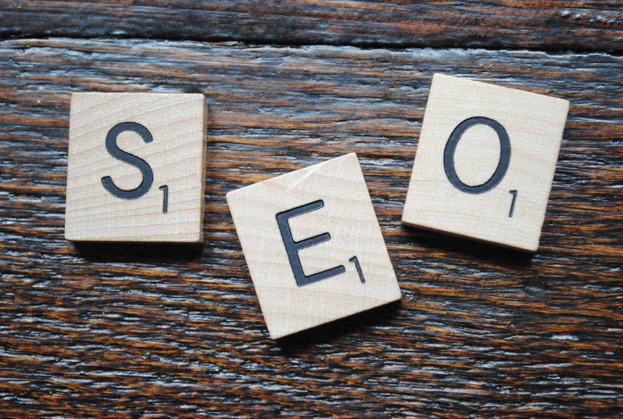 services-03 Close-up view of Scrabble tiles arranged to spell SEO on a wooden table for content strategy.